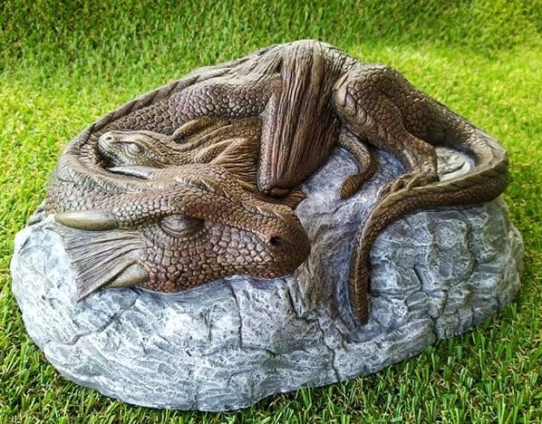 Dragon and her baby snuggling on a rock garden ornament
